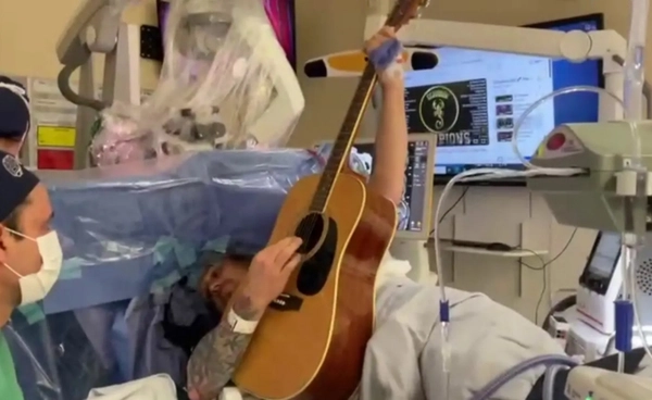 คนไข้โชว์ฝีมือเล่นกีตาร์ ระหว่างการผ่าตัดเปิดกะโหลก